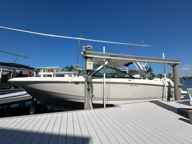 Slide: The Image of Boston Whaler 320 Vantage 2018 boat docked by a scenic waterfront with clear skies. - 5