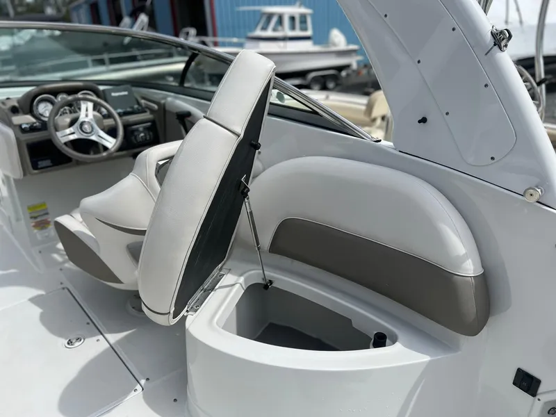 Slide: The Image of 2016 Crownline Eclipse E4 XS boat interior with open storage compartment and steering wheel. - 28