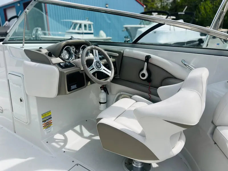 Slide: The Image of 2016 Crownline Eclipse E4 XS boat cockpit with steering wheel and white seating. - 6