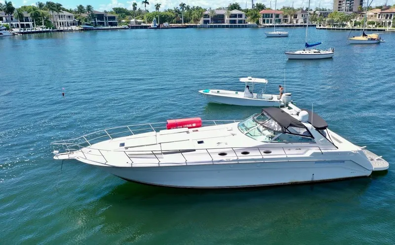 Slide: The Image of 1998 Sea Ray 500 Sundancer yacht on calm water, surrounded by other boats. - 1
