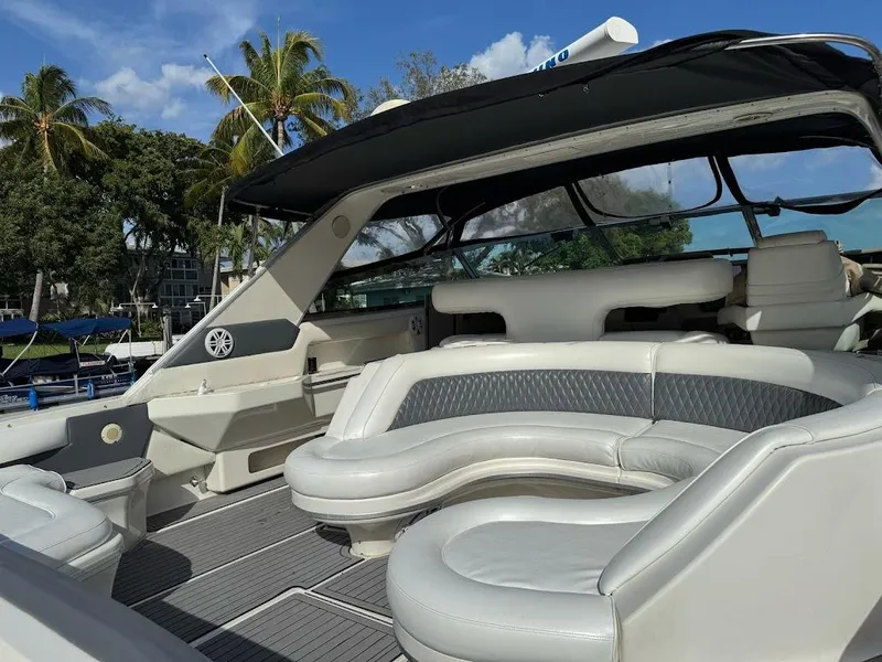 Slide: The Image of 1998 Sea Ray 500 Sundancer yacht with spacious seating, docked under clear skies and palm trees. - 10