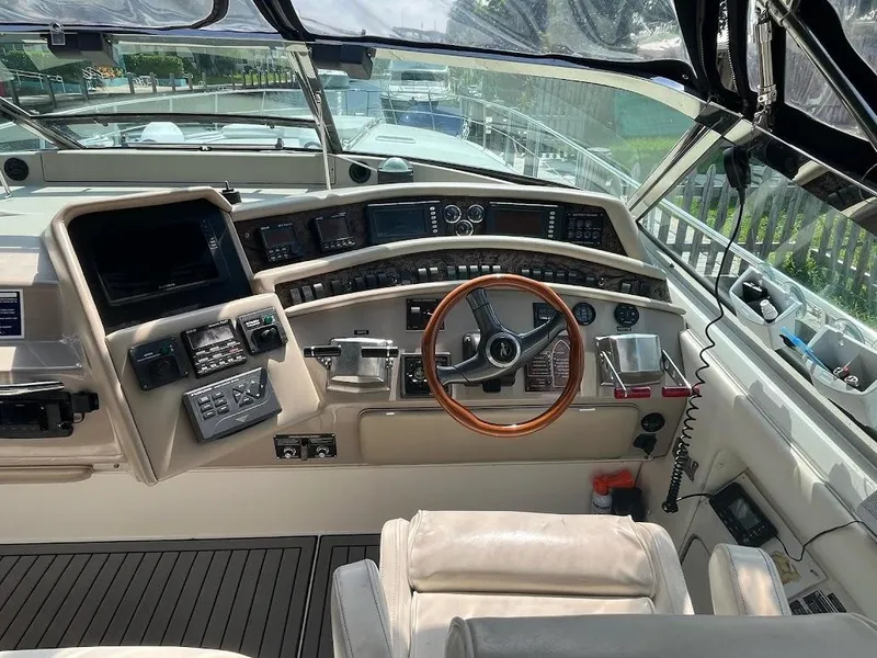 Slide: The Image of 1998 Sea Ray 500 Sundancer helm with wood steering wheel and modern navigation controls. - 11