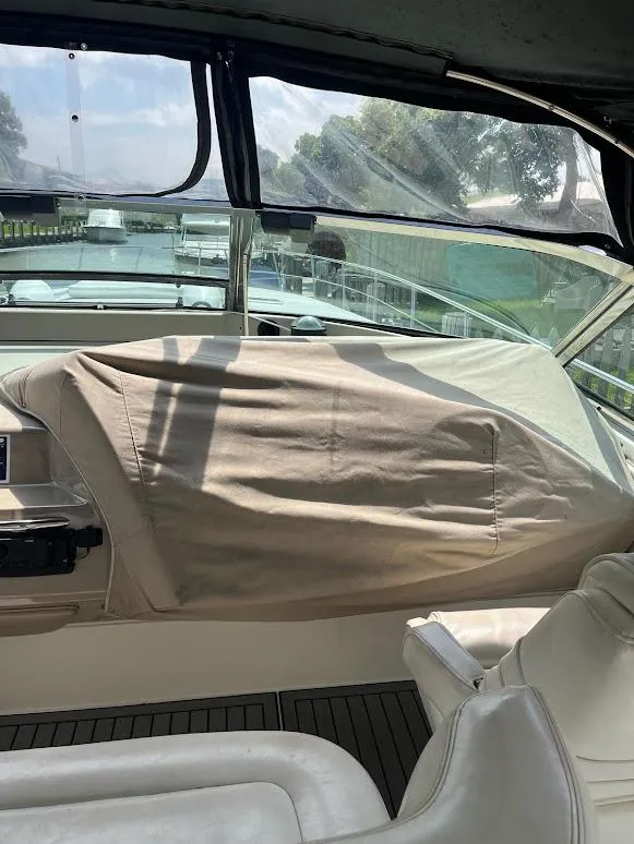 Slide: The Image of 1998 Sea Ray 500 Sundancer cockpit with covered dashboard and leather seating. - 12