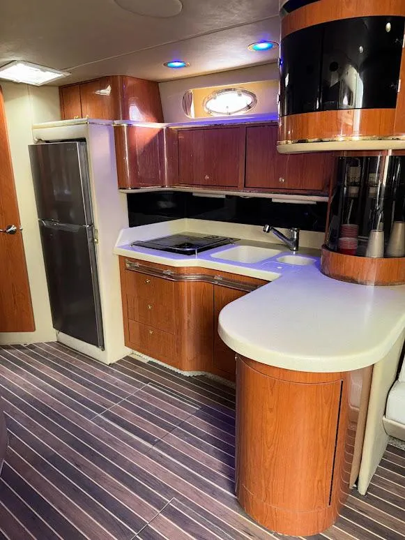 Slide: The Image of Luxurious 1998 Sea Ray 500 Sundancer yacht kitchen with modern wood cabinetry and sleek countertops. - 14