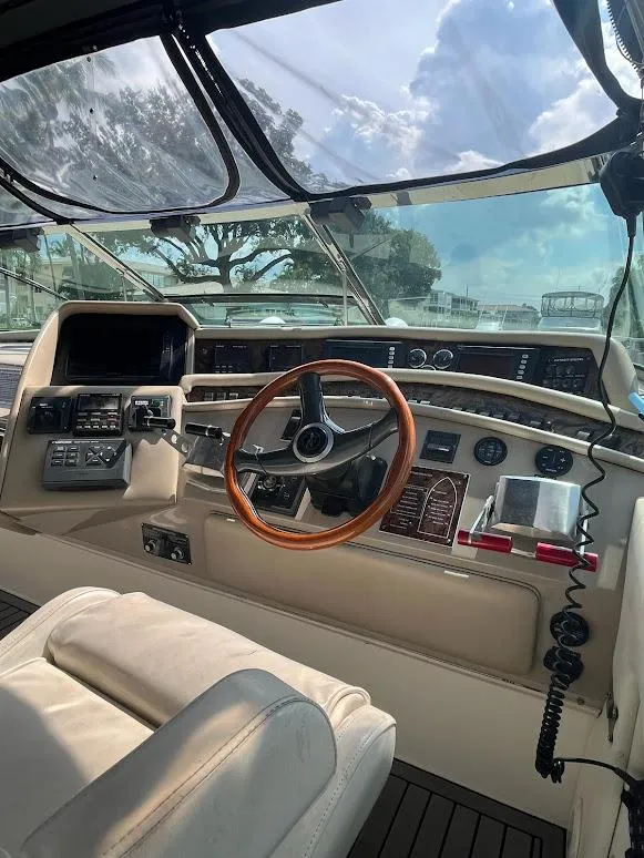 Slide: The Image of 1998 Sea Ray 500 Sundancer helm with wooden steering wheel and navigation controls. - 16