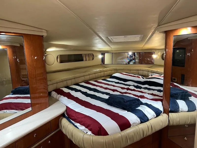 Slide: The Image of Luxurious cabin interior of 1998 Sea Ray 500 Sundancer with striped bedding and wood accents. - 20