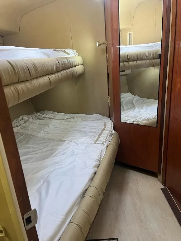 Slide: The Image of 1998 Sea Ray 500 Sundancer cabin with bunk beds and mirrored door. - 21