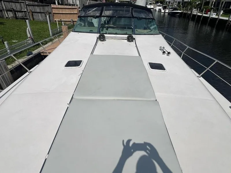 Slide: The Image of 1998 Sea Ray 500 Sundancer yacht deck with sunpad, docked by a canal. - 4