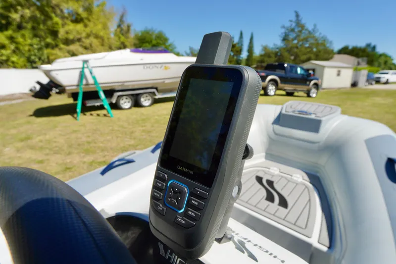 Slide: The Image of 2023 Highfield Classic 340 GT boat with Garmin GPS, parked near a trailer and truck. - 11