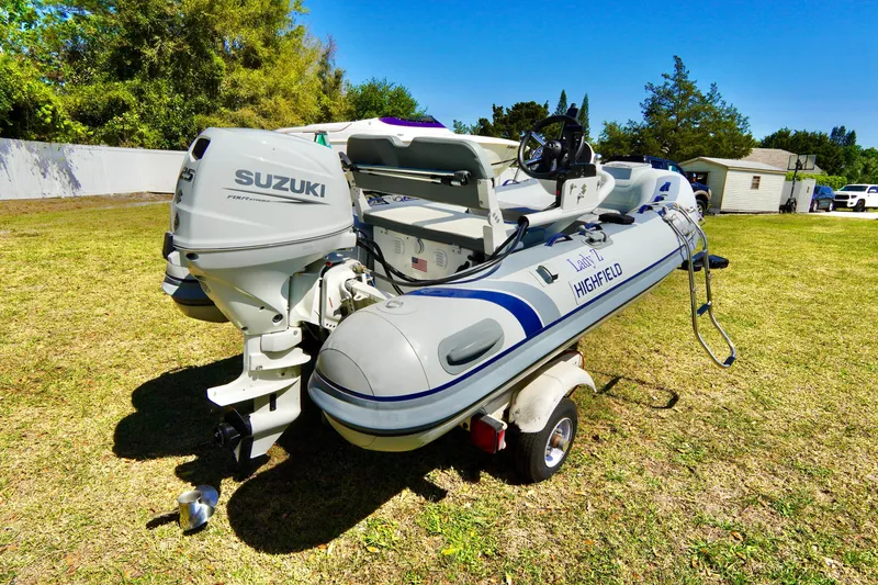 Slide: The Image of 2023 Highfield Classic 340 GT boat with Suzuki outboard motor on a grassy area. - 18