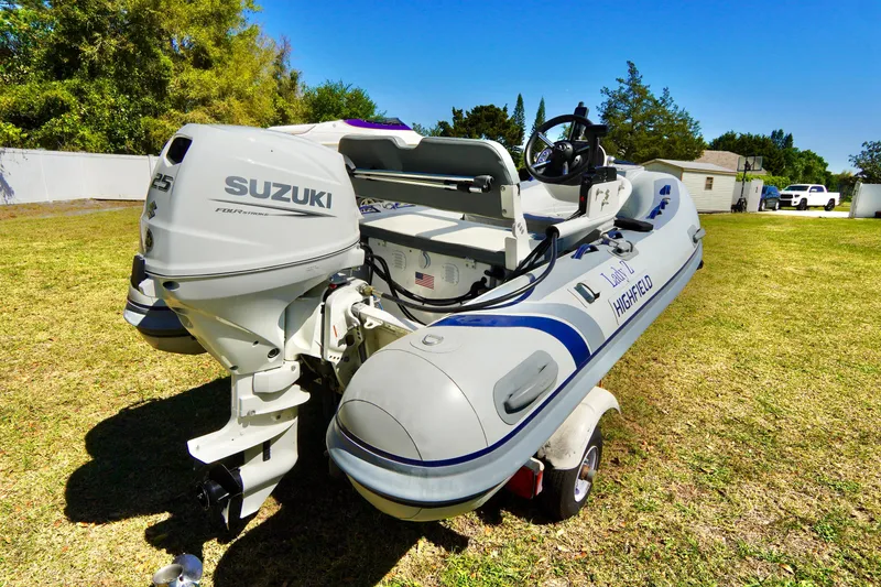 Slide: The Image of 2023 Highfield Classic 340 GT boat with Suzuki engine on grassy area. - 19