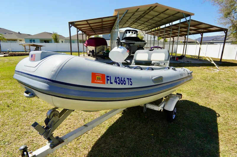 Slide: The Image of 2023 Highfield Classic 340 GT inflatable boat on trailer, parked outdoors. - 2