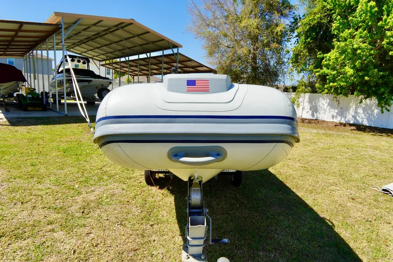 Slide: The Image of 2023 Highfield Classic 340 GT boat on trailer, displayed outdoors with American flag. - 3