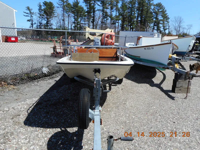 Slide: The Image of 1986 Boston Whaler 13 Super Sport on trailer, parked outdoors near other boats. - 2