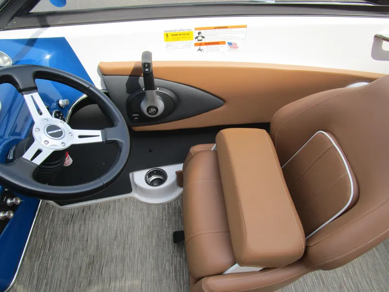Slide: The Image of 2018 Glastron GT180 boat interior with steering wheel and brown seating. - 15