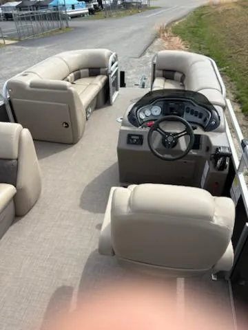 Slide: The Image of 2023 Sun Tracker Party Barge 20 DLX interior with beige seating and steering console. - 43