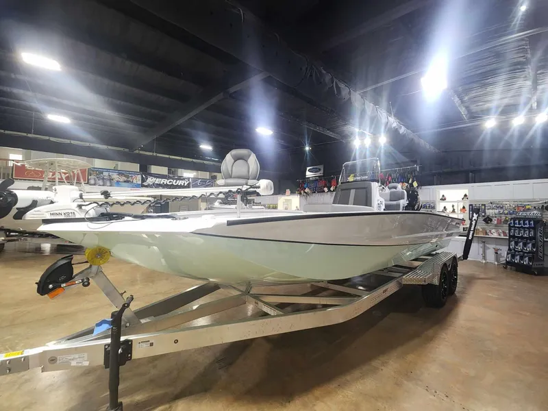 Slide: The Image of 2025 Xpress X23B Lounge boat displayed indoors on a trailer. - 1