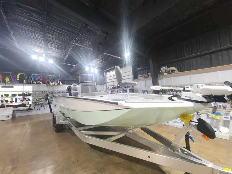 Slide: The Image of 2025 Xpress X23B Lounge boat displayed in a showroom with bright overhead lighting. - 10