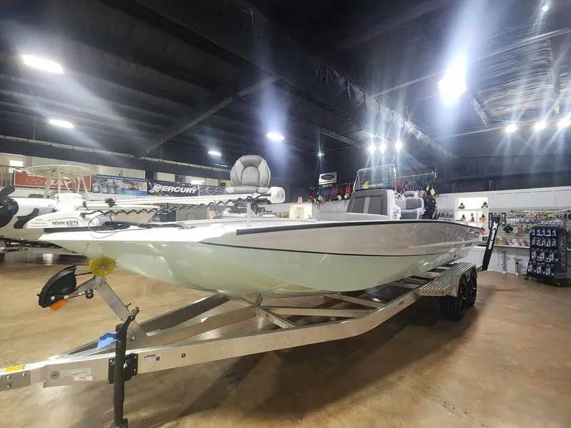 Slide: The Image of 2025 Xpress X23B Lounge boat displayed indoors on a trailer. - 12