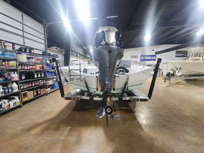 Slide: The Image of 2025 Xpress X23B Lounge boat in a showroom, rear view with motor and equipment. - 9