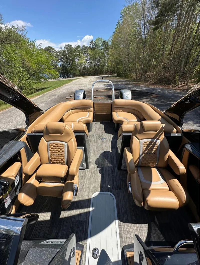 Slide: The Image of Luxurious 2023 Crest Continental NX 270 boat interior with tan leather seating and scenic outdoor backdrop. - 10