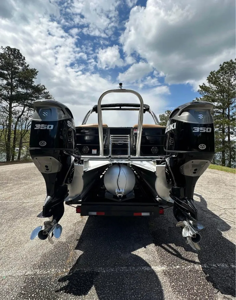 Slide: The Image of 2023 Crest Continental NX 270 boat with dual Suzuki 350 engines, parked outdoors. - 20