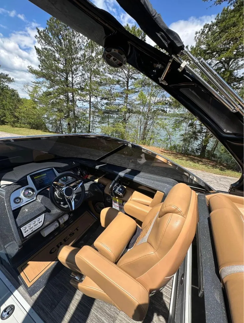 Slide: The Image of 2023 Crest Continental NX 270 boat interior with tan leather seats and modern dashboard. - 4