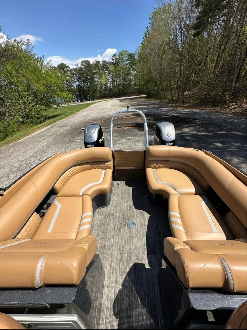 Slide: The Image of 2023 Crest Continental NX 270 boat with tan seating on a scenic road. - 7