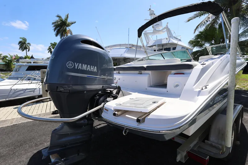 Slide: The Image of 2022 Regal 21 OBX boat with Yamaha outboard motor, docked near palm trees. - 15