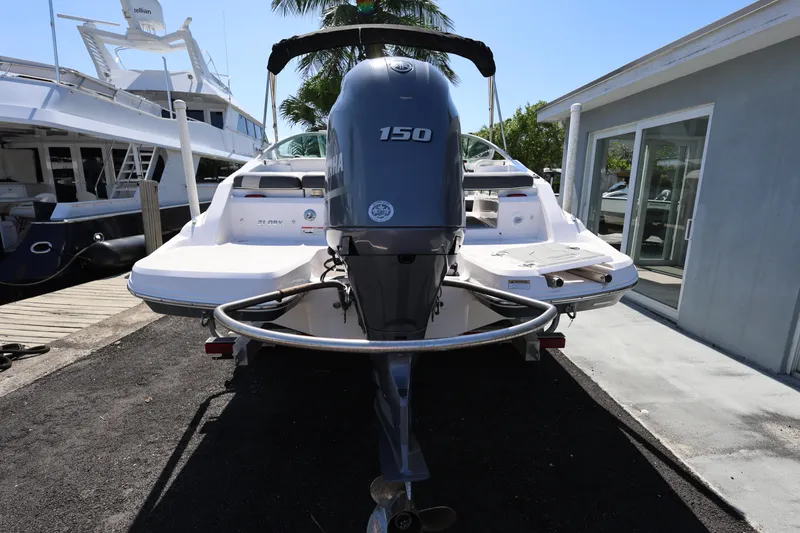 Slide: The Image of 2022 Regal 21 OBX boat with 150 HP outboard motor, docked near a marina. - 16