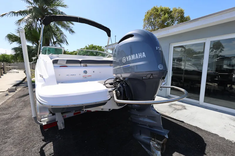 Slide: The Image of 2022 Regal 21 OBX boat with Yamaha outboard motor, parked near a building. - 17