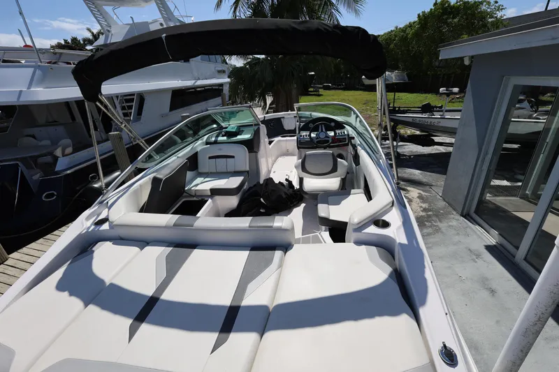 Slide: The Image of 2022 Regal 21 OBX boat with spacious seating and sleek design at a marina. - 21