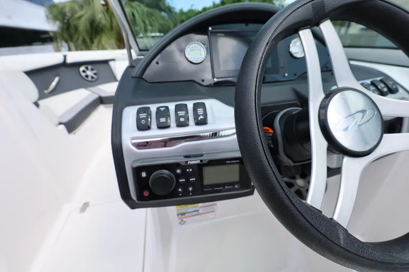 Slide: The Image of 2022 Regal 21 OBX boat dashboard with steering wheel and control panel. - 32