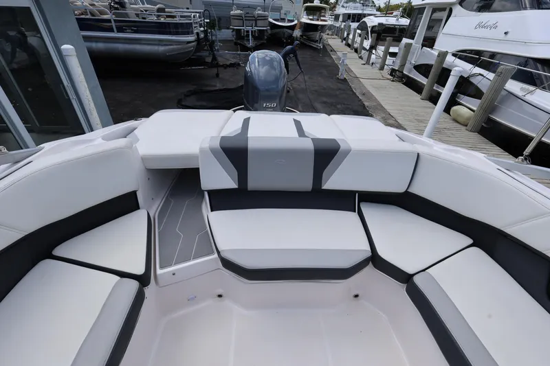 Slide: The Image of 2022 Regal 21 OBX boat interior with white and gray seating at a marina. - 34