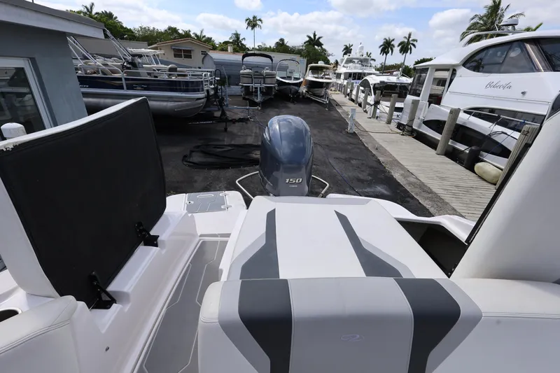 Slide: The Image of 2022 Regal 21 OBX boat with outboard motor, docked among other vessels. - 37