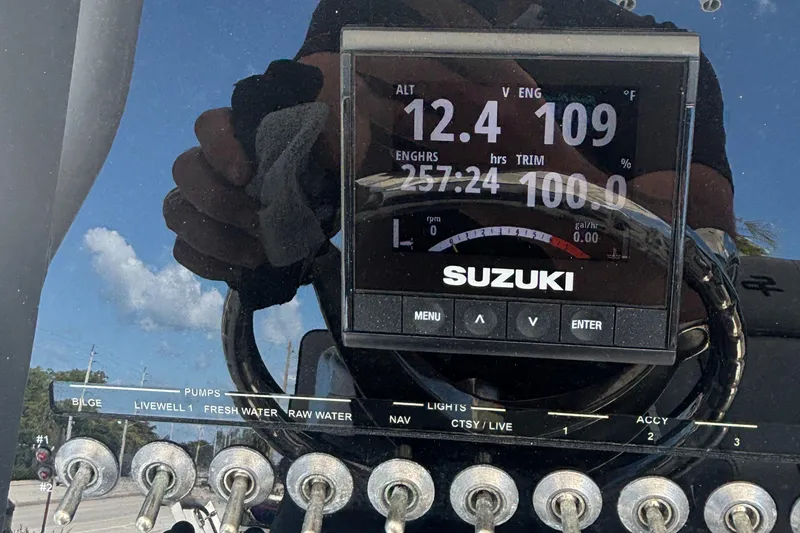 Slide: The Image of 2021 Sea Pro 239 Center Console dashboard with Suzuki engine display and control switches. - 15