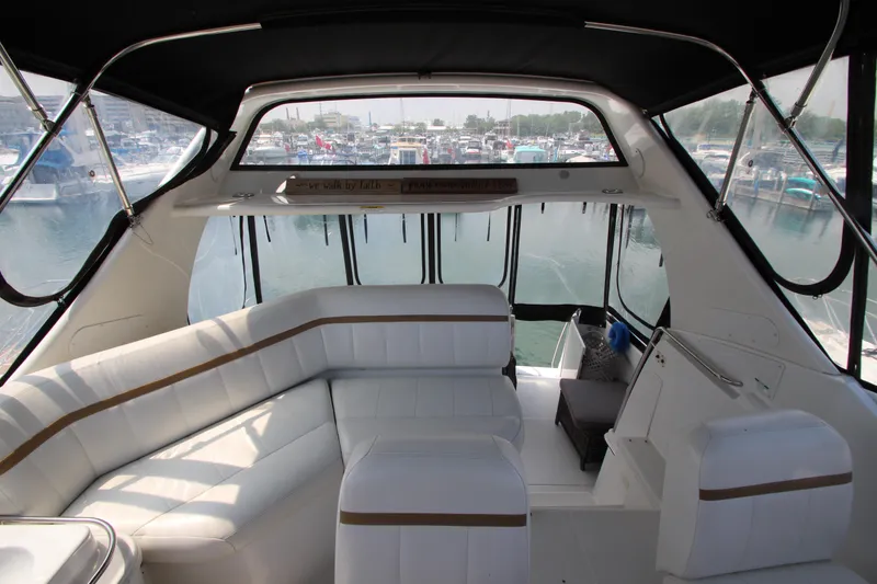Slide: The Image of 2002 Carver 366 Motor Yacht interior with white seating and marina view. - 11