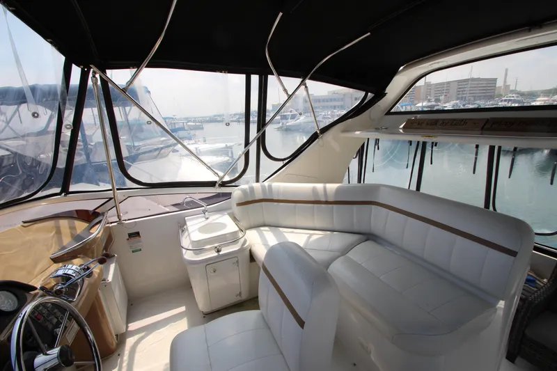 Slide: The Image of Interior of 2002 Carver 366 Motor Yacht with white seating and marina view. - 13