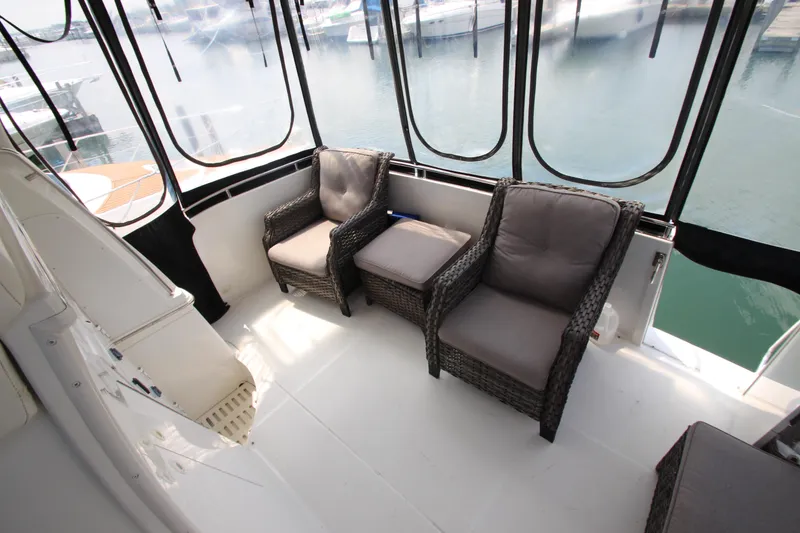 Slide: The Image of 2002 Carver 366 Motor Yacht interior with wicker chairs and marina view. - 17