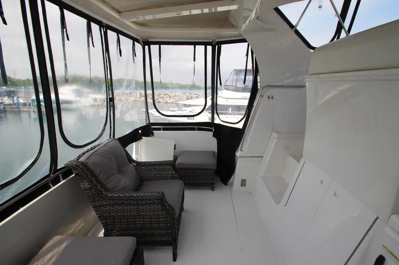 Slide: The Image of 2002 Carver 366 Motor Yacht interior with wicker seating and panoramic windows. - 18