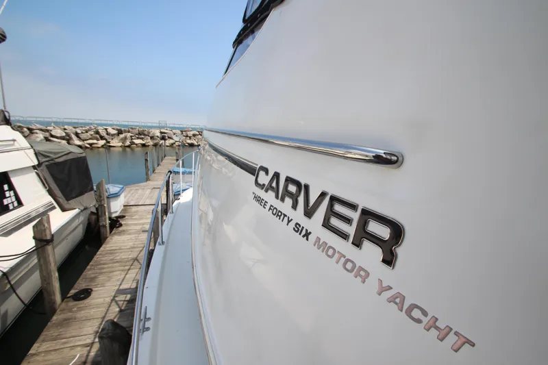 Slide: The Image of 2002 Carver 366 Motor Yacht docked at marina, side view with logo. - 24