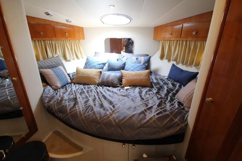 Slide: The Image of Luxurious bedroom in 2002 Carver 366 Motor Yacht with cozy bedding and wooden cabinets. - 38