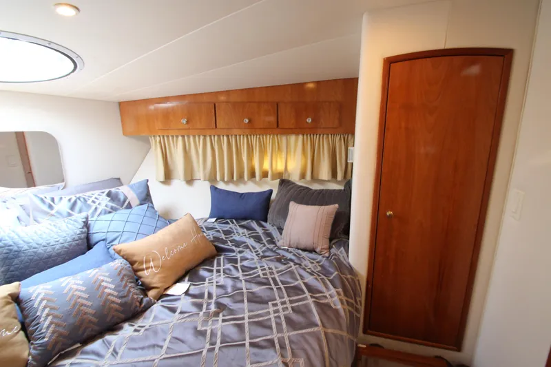 Slide: The Image of Cozy bedroom in 2002 Carver 366 Motor Yacht with wood accents and plush bedding. - 39
