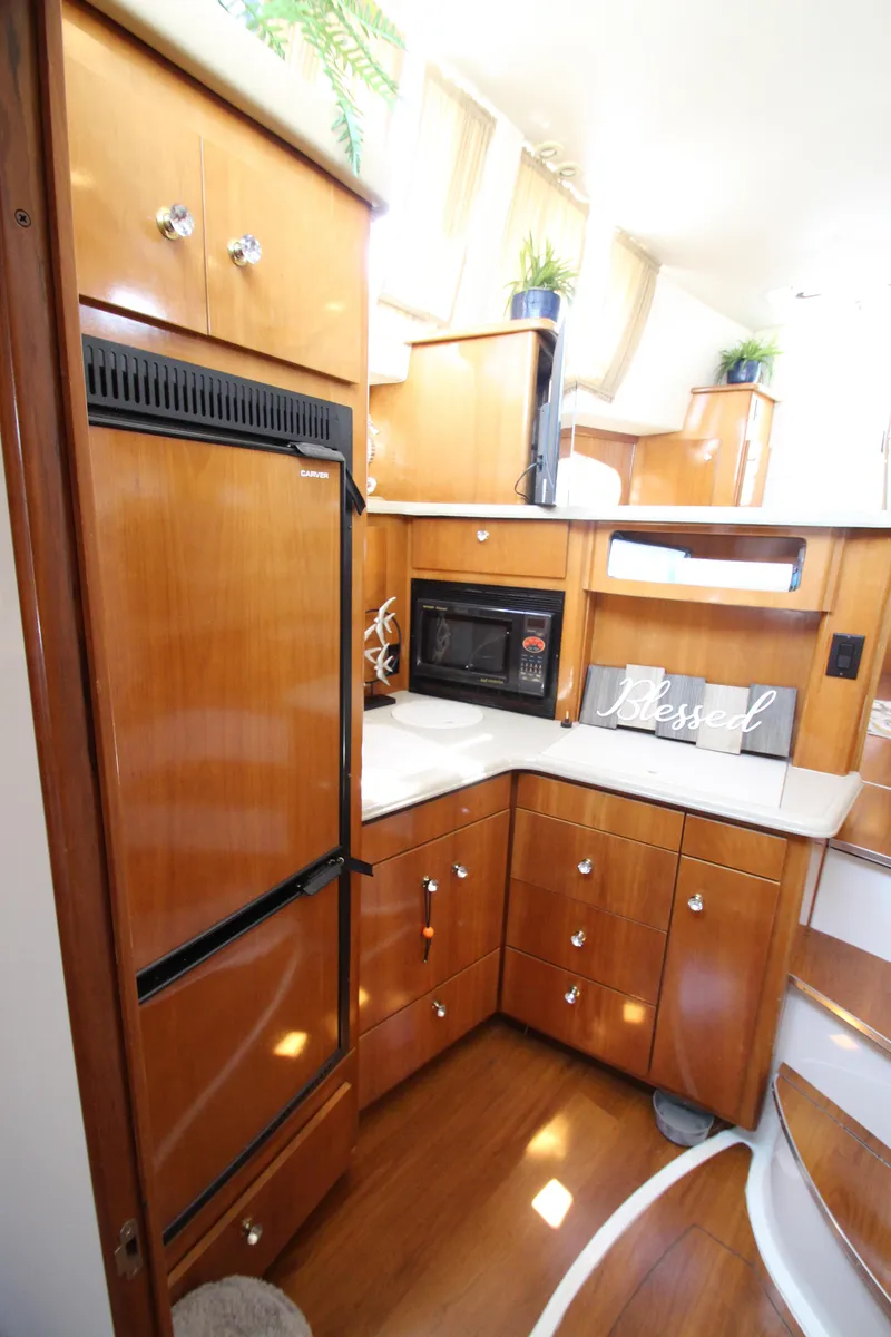 Slide: The Image of 2002 Carver 366 Motor Yacht kitchen with wood cabinetry, microwave, and refrigerator. - 40