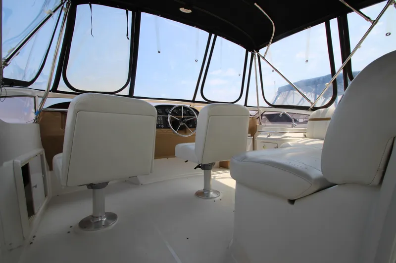 Slide: The Image of Interior of 2002 Carver 366 Motor Yacht with white seating and panoramic windows. - 6