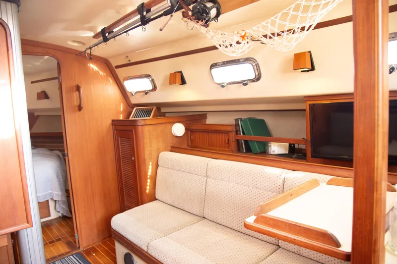Slide: The Image of Interior of 1999 Island Packet 380 sailboat with cozy seating and wooden finishes. - 10