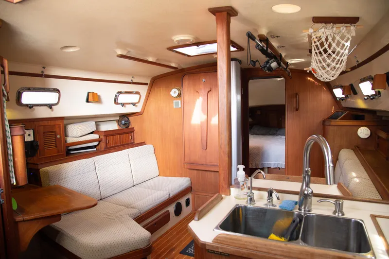 Slide: The Image of Interior of 1999 Island Packet 380 sailboat with cozy seating and kitchen area. - 11