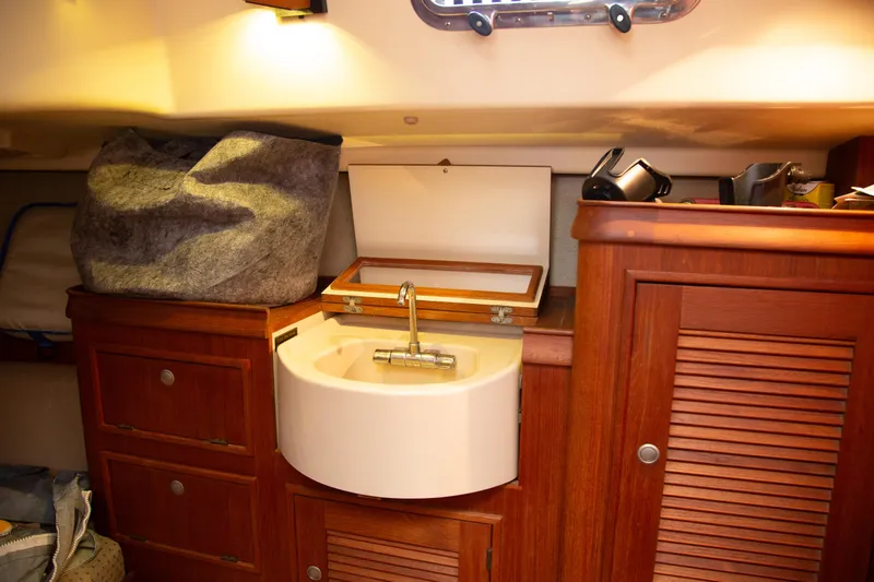 Slide: The Image of Interior of 1999 Island Packet 380 sailboat with wooden cabinetry and compact sink. - 15
