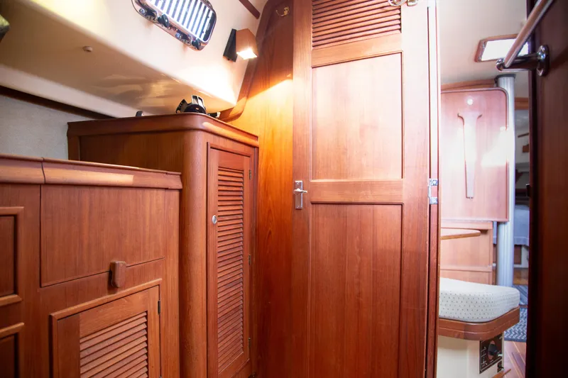 Slide: The Image of Interior of 1999 Island Packet 380 sailboat with wooden cabinetry and seating area. - 16