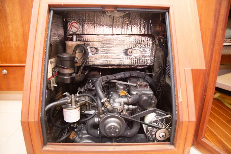 Slide: The Image of Engine compartment of a 1999 Island Packet 380 sailboat, showcasing mechanical components and insulation. - 17